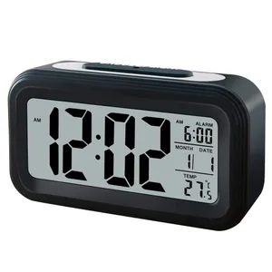 Reloj despertador en una mesita de noche que muestra las primeras horas de  la mañana